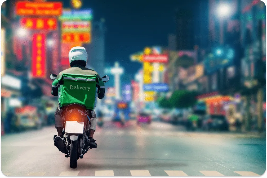 Motorbike courier making a nighttime delivery
