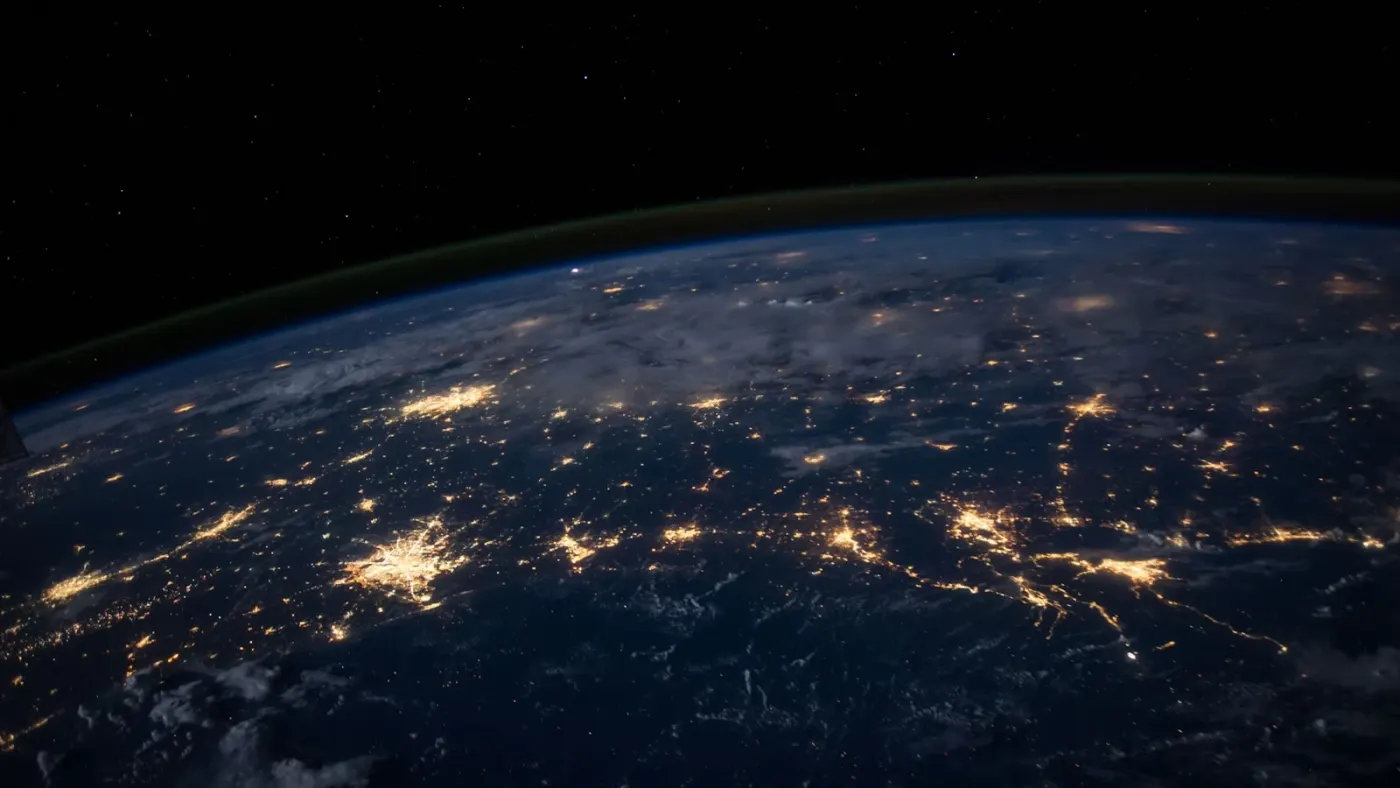 Earth from space at night showing interconnected networks of city lights representing global messaging connectivity