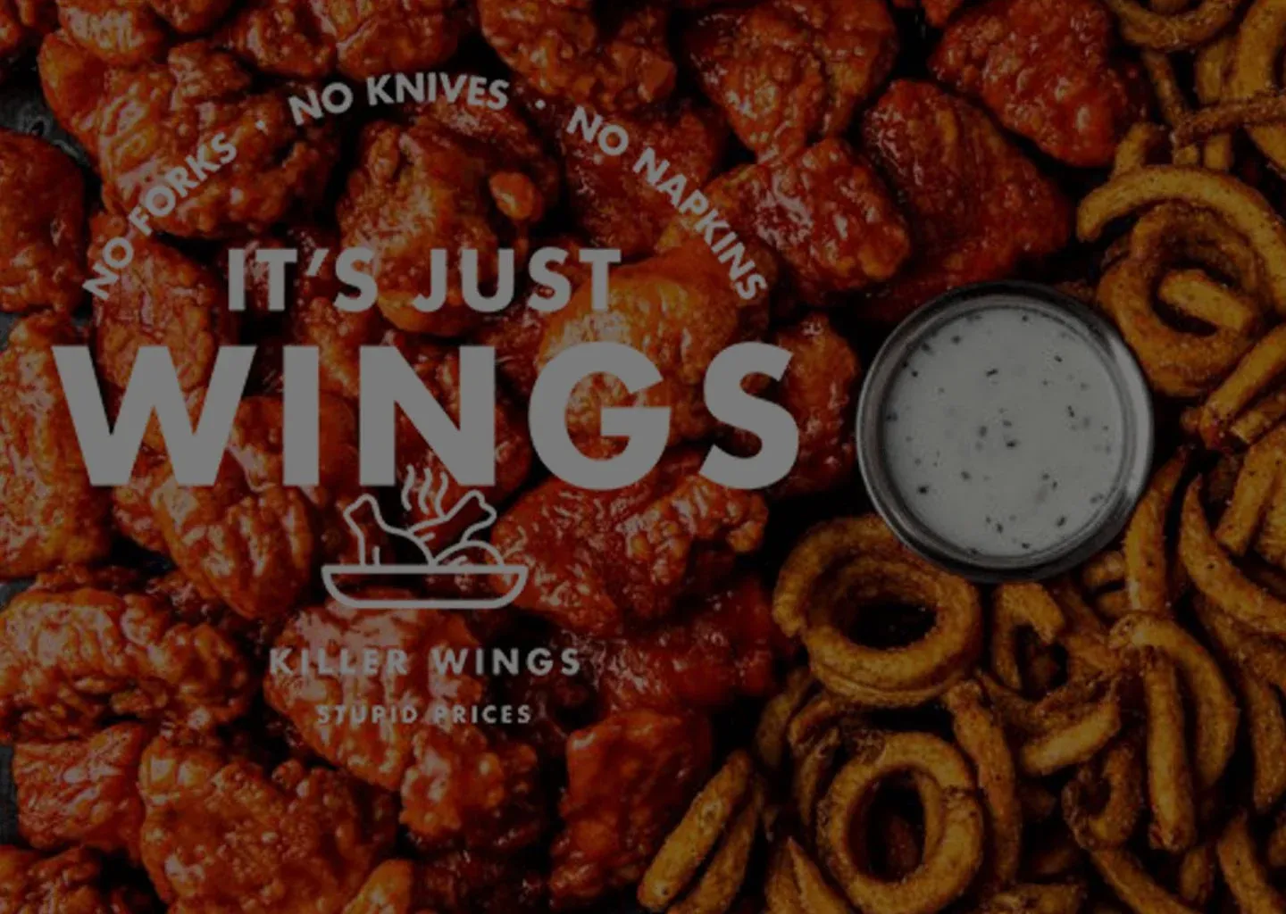 It's Just Wings logo over a spread of sauced boneless wings, curly fries, and a cup of ranch