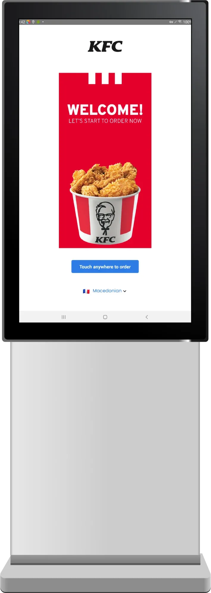 Standing KFC kiosk with a welcome screen, a bucket of chicken, a Touch anywhere to order button, and a Macedonian language option