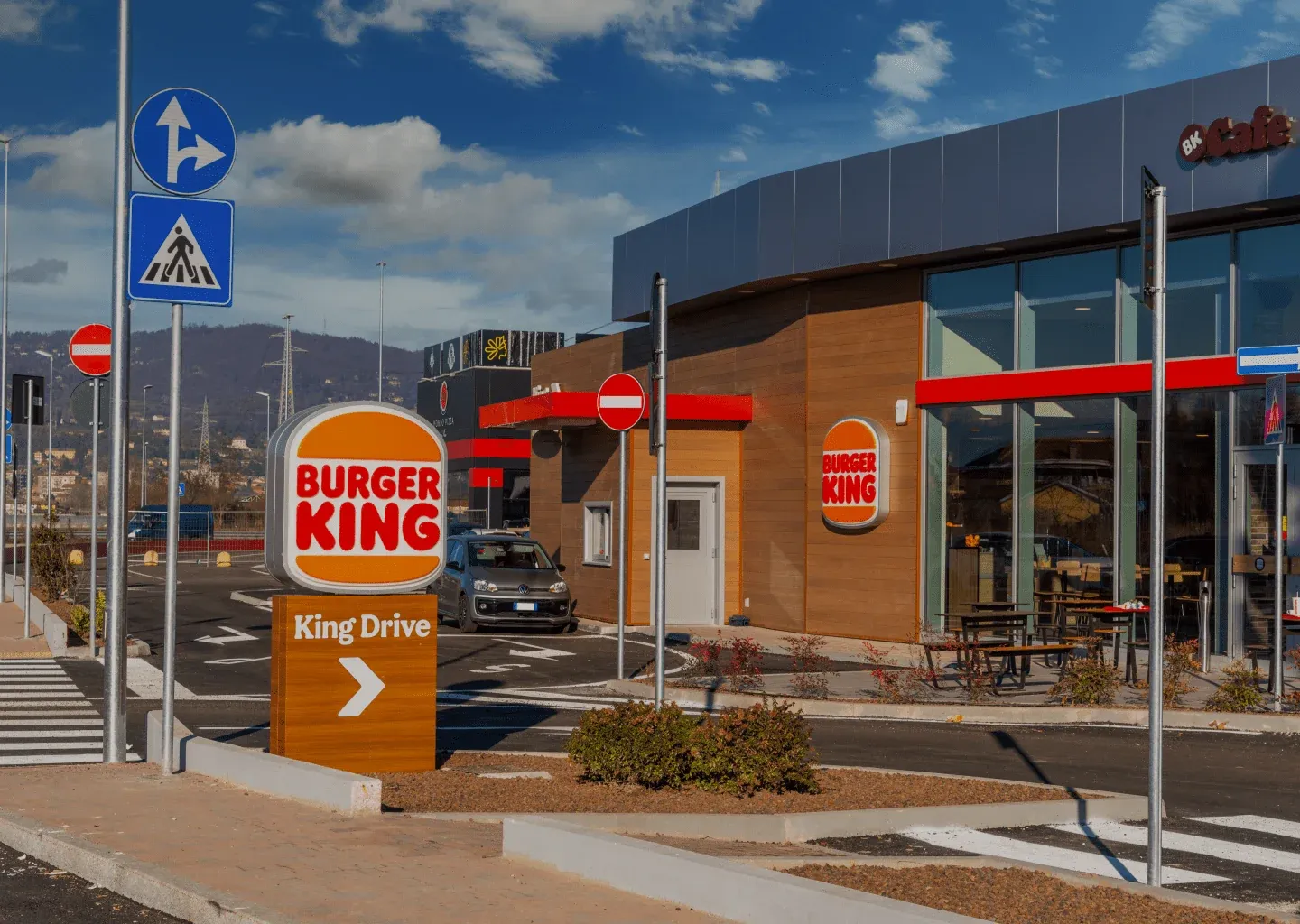 A Burger King restaurant with a King Drive drive-thru sign and outdoor seating
