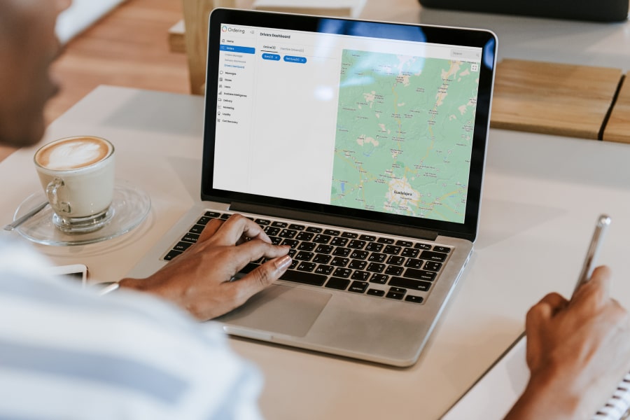 Operator reviewing the Drivers Dashboard on a laptop, with online and inactive driver tabs beside a driver map